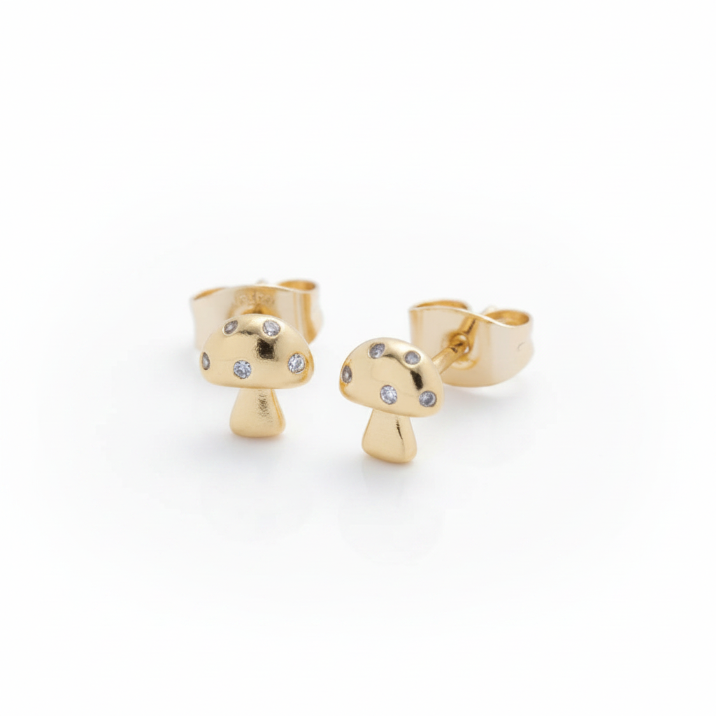 Gold mushroom-shaped earrings with small stones on a light gray background