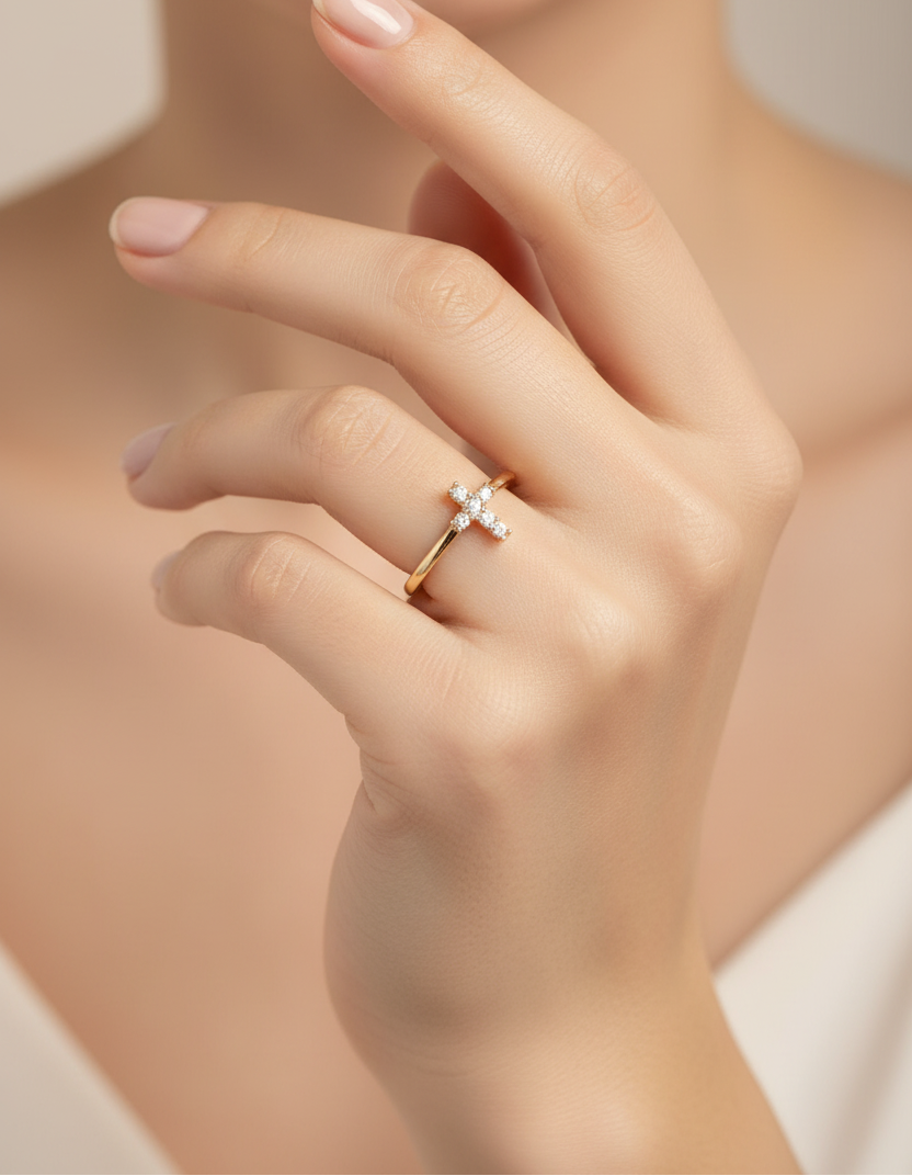 Hand wearing a gold ring with a pearl on a neutral background