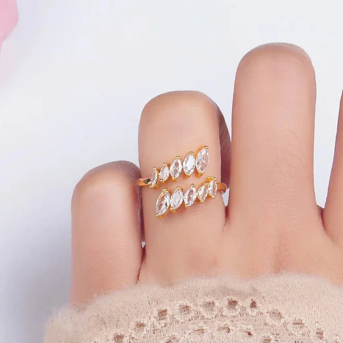 Hand wearing a gold ring with diamonds on background