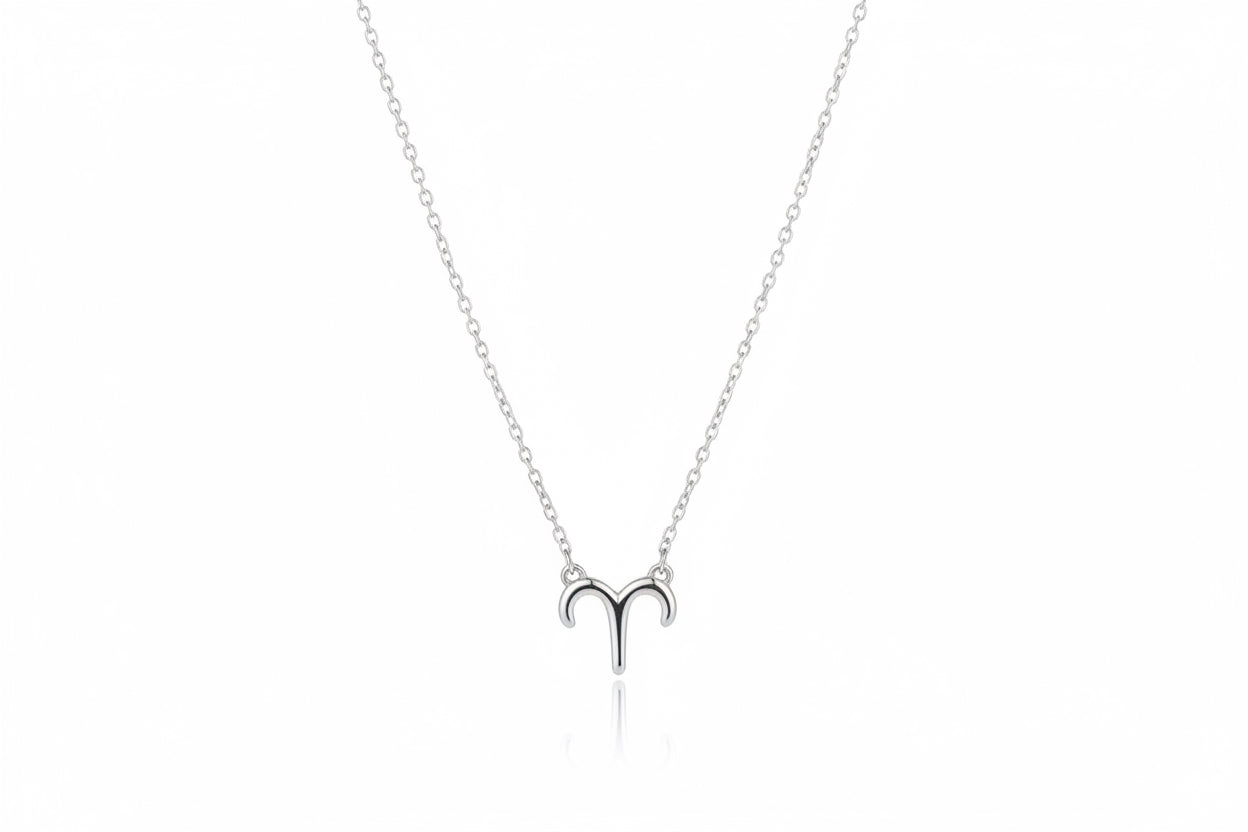 Silver Aries zodiac symbol necklace on a brown surface