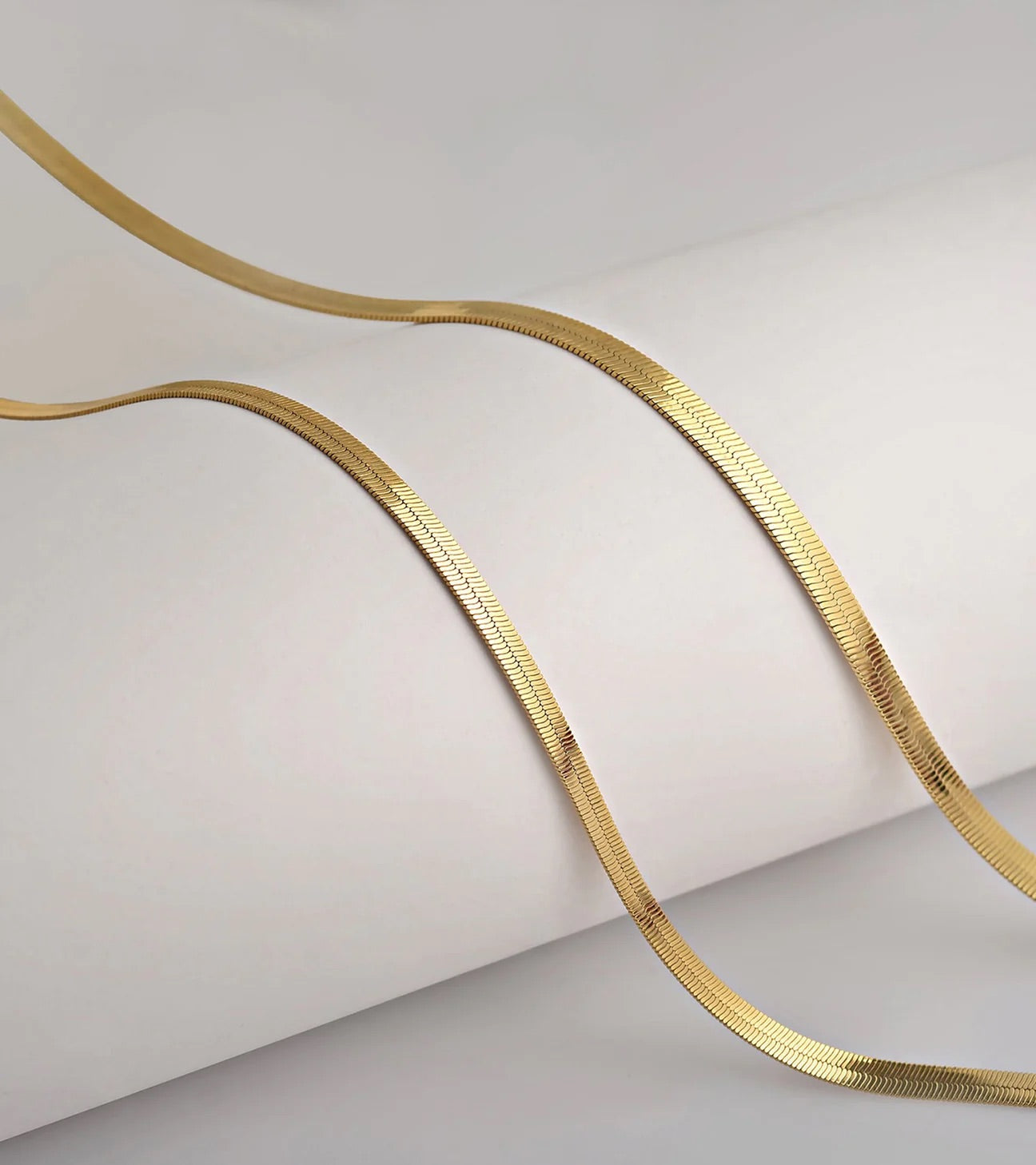 Gold chain on a light gray background