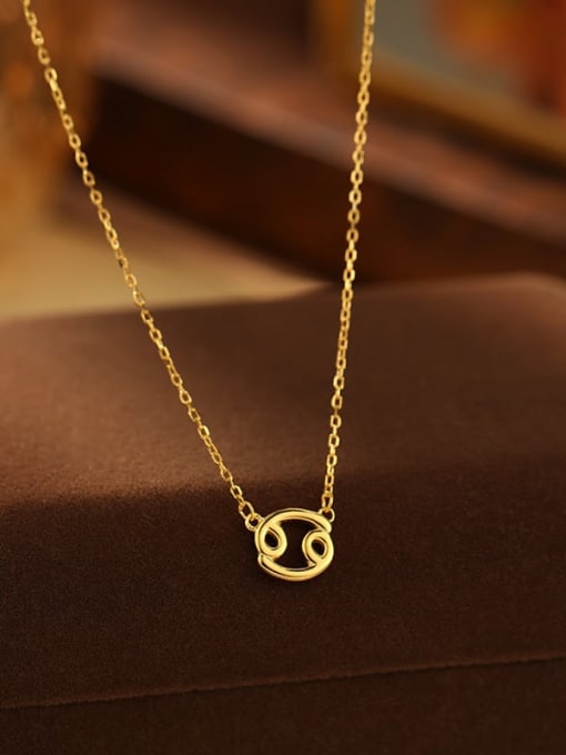 Gold necklace with a zodiac symbol pendant on a brown surface