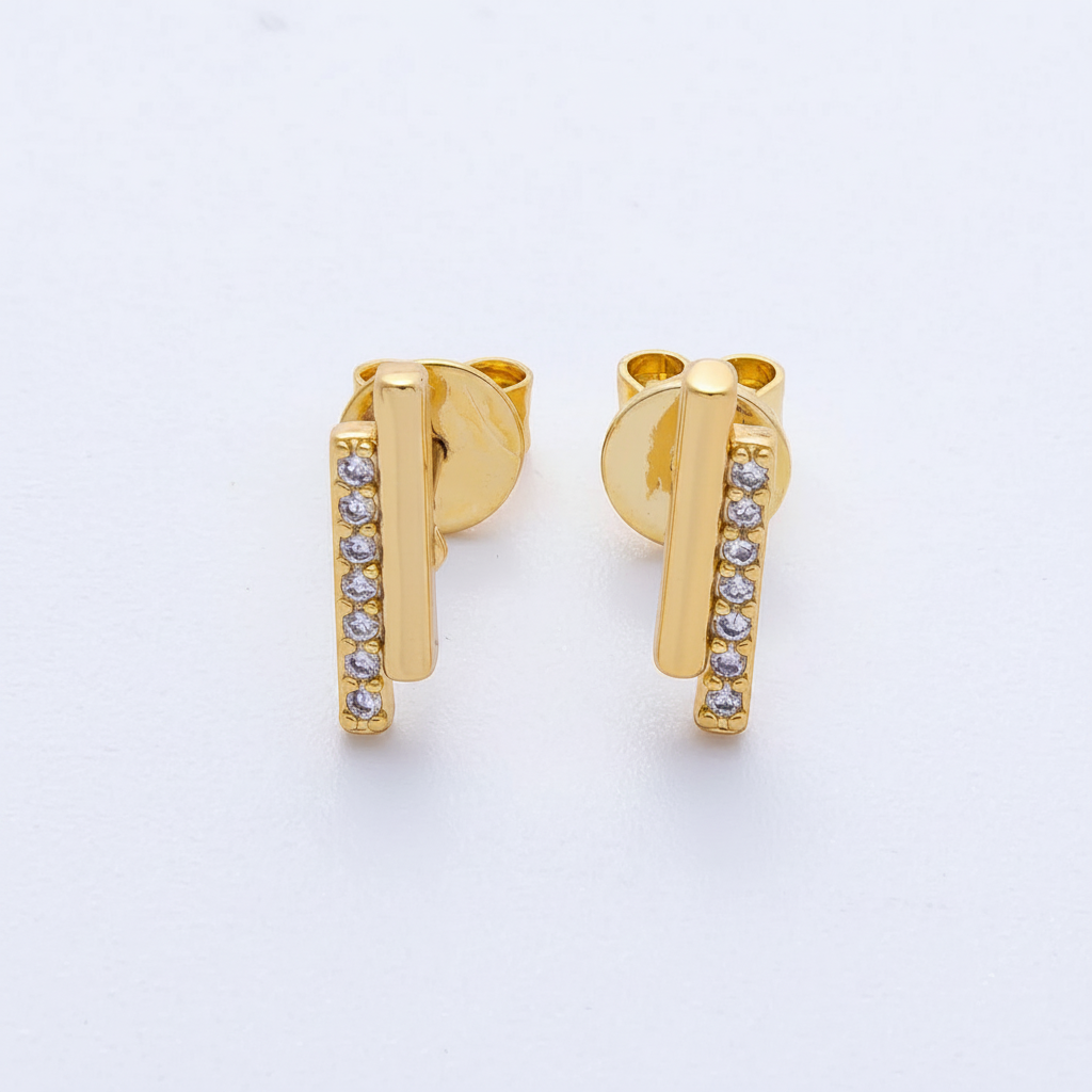 Gold earrings with small diamonds on a light gray background