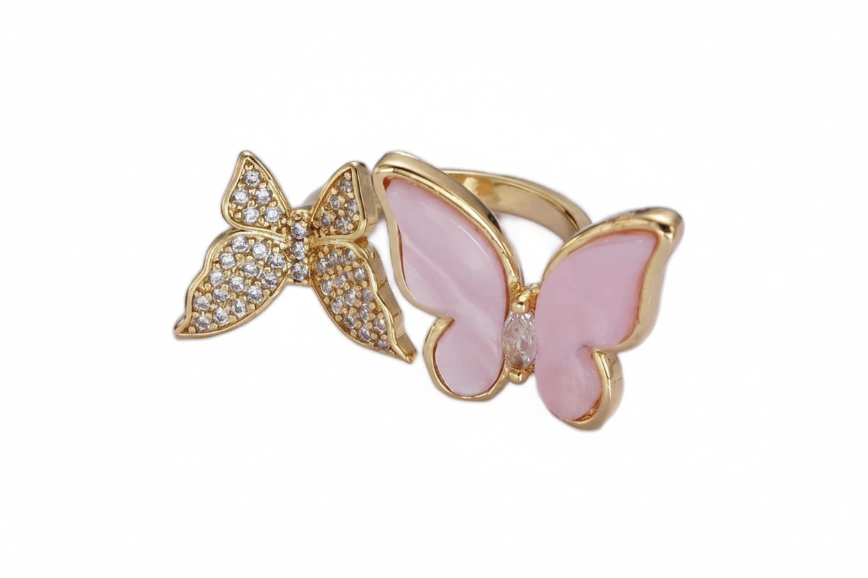 Gold ring with pink butterfly design on a white background