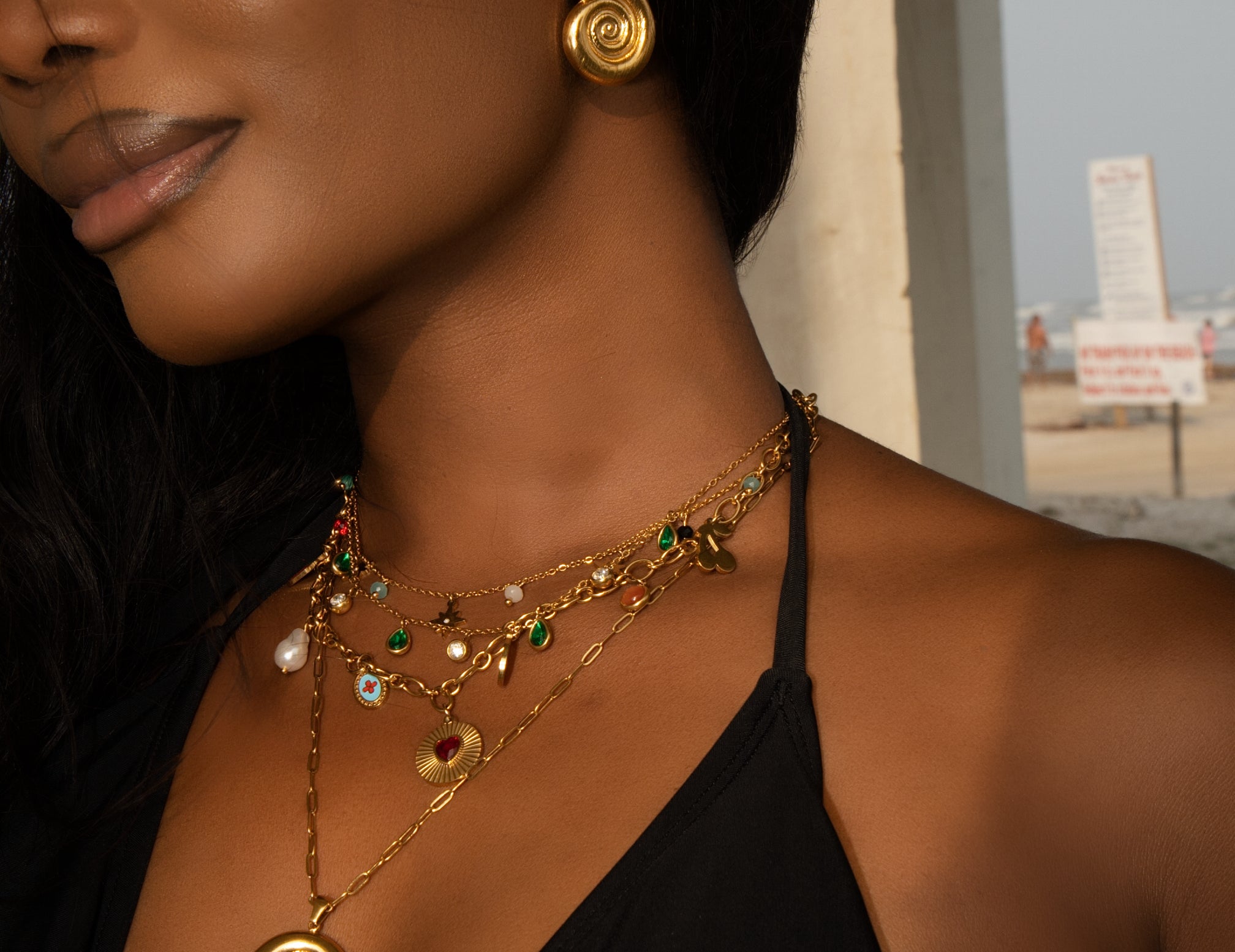Woman wearing gold jewelry with a blurred background