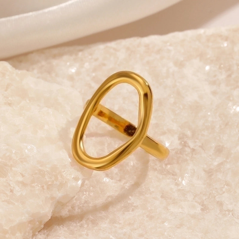 Gold ring on a textured beige surface