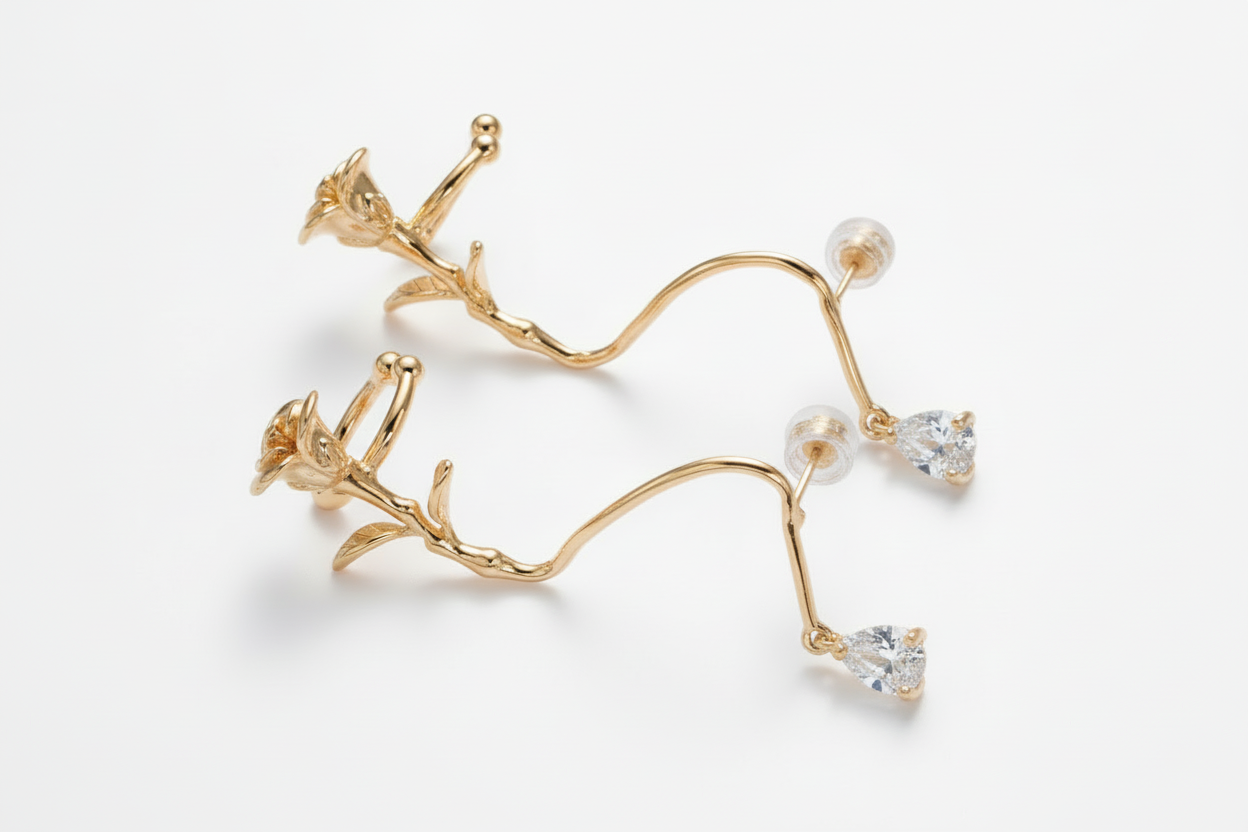 Gold earrings with clear gemstones on a white background