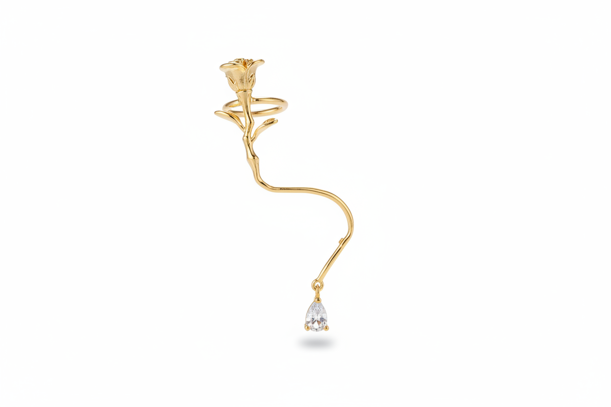Gold ear cuff with a small diamond on a white background