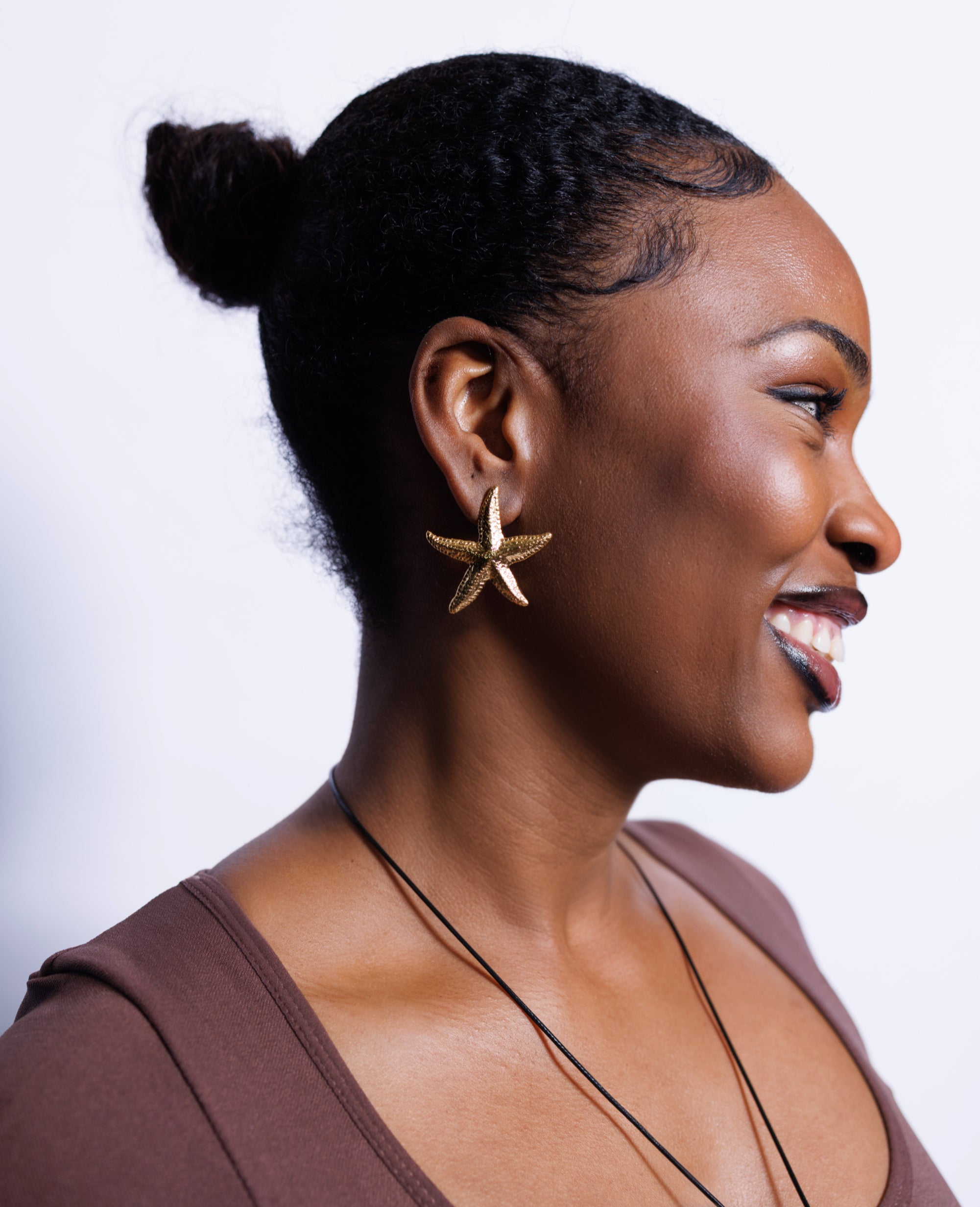 Woman wearing a star-shaped earring on a white background