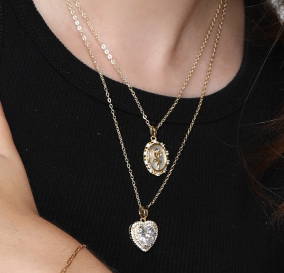 Two gold necklaces with pendants on a black background
