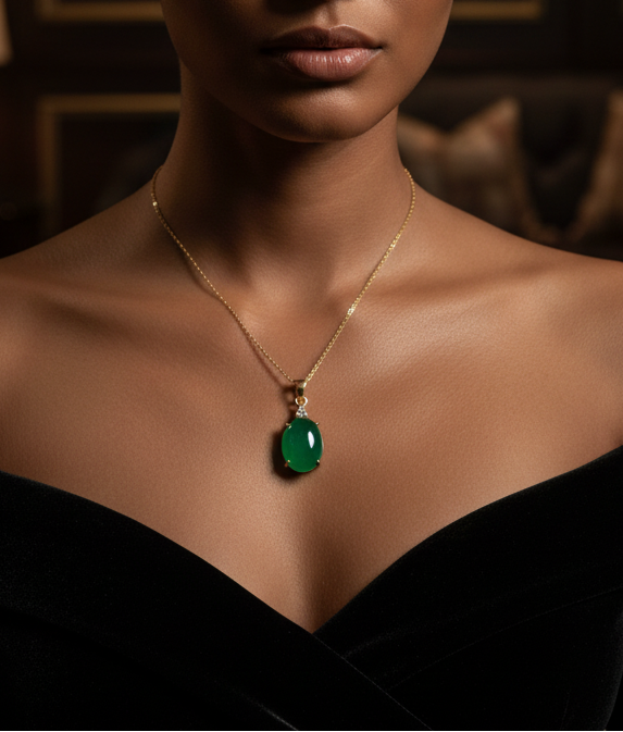 Woman wearing a black off-shoulder top and a green pendant necklace in a dimly lit room.