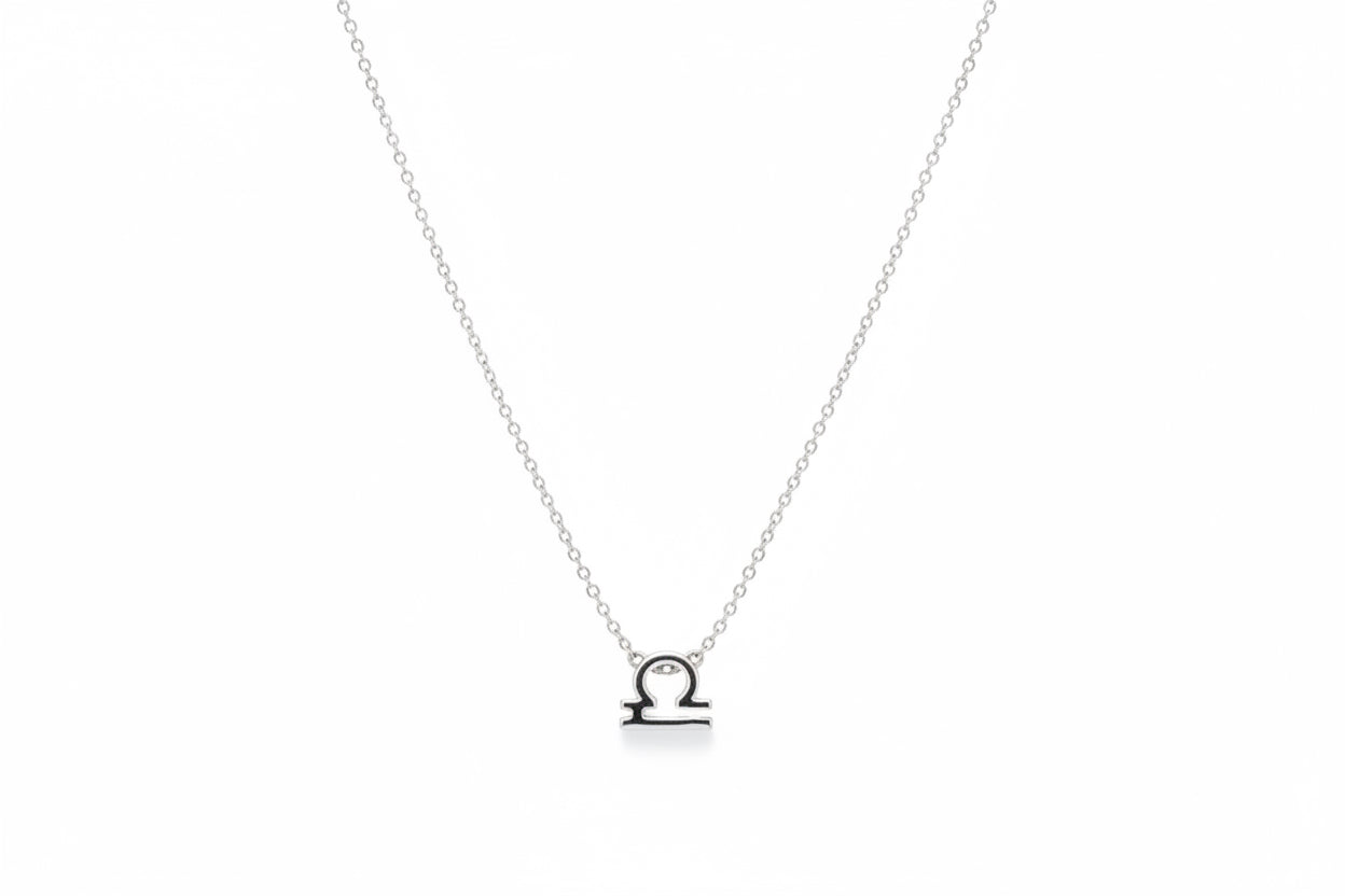 Silver Libra zodiac necklace on a white surface