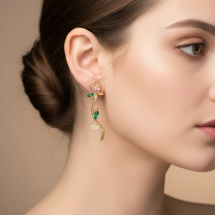 Close-up of a woman wearing gold earrings with green gemstones against a beige background