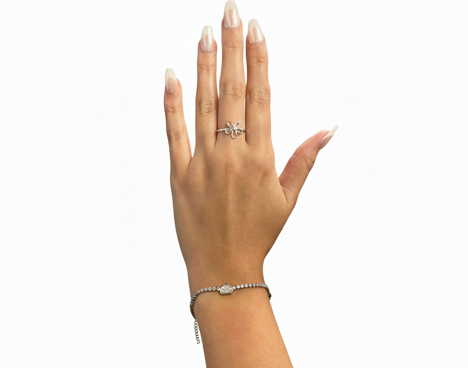 Hand wearing a silver ring and bracelet on a white background