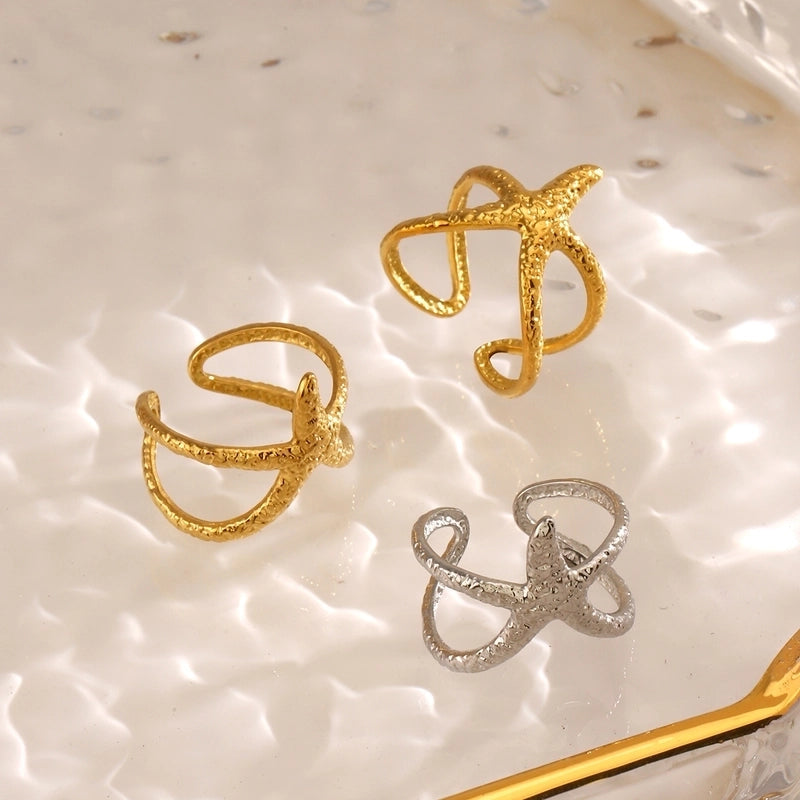 Gold and silver rings on a textured beige surface