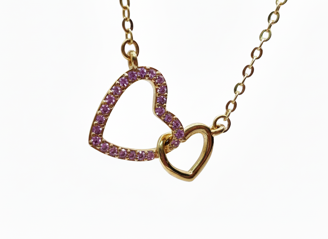 Gold necklace with heart-shaped pendants on a white background