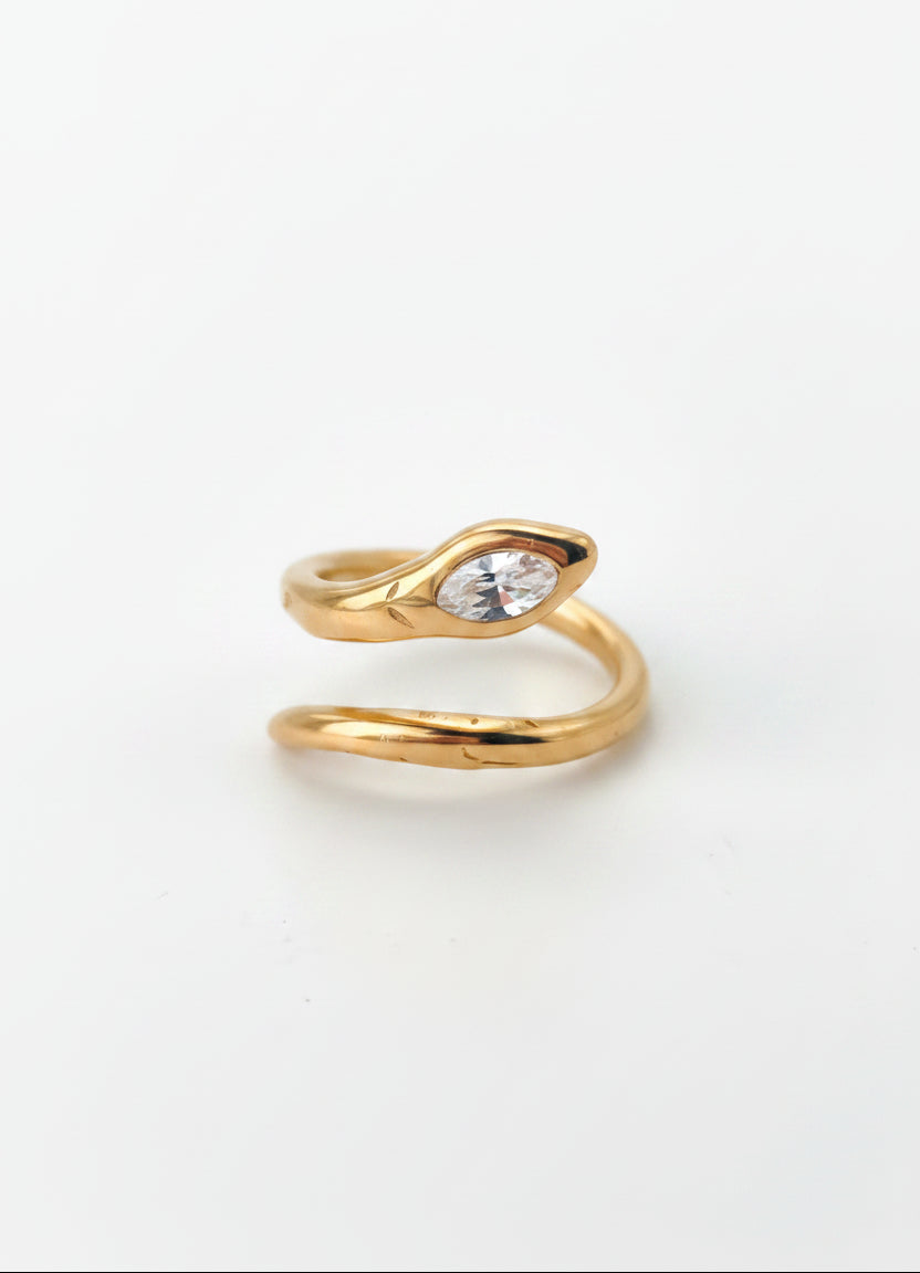A gold-plated stainless steel snake ring with a marquise-cut clear gemstone on a plain white background, with product specifications printed in black text in the bottom-left corner.