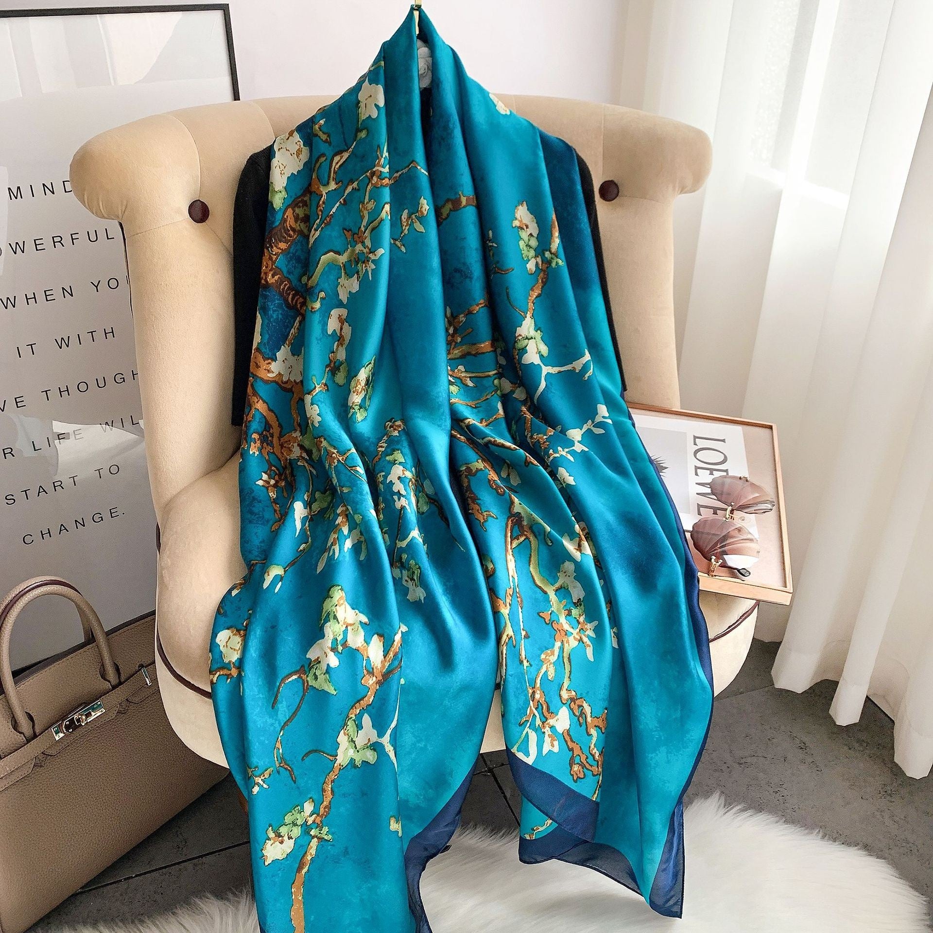 Teal scarf with floral pattern draped over a chair in a room.