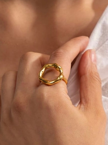 Gold ring on a person's finger with a blurred background