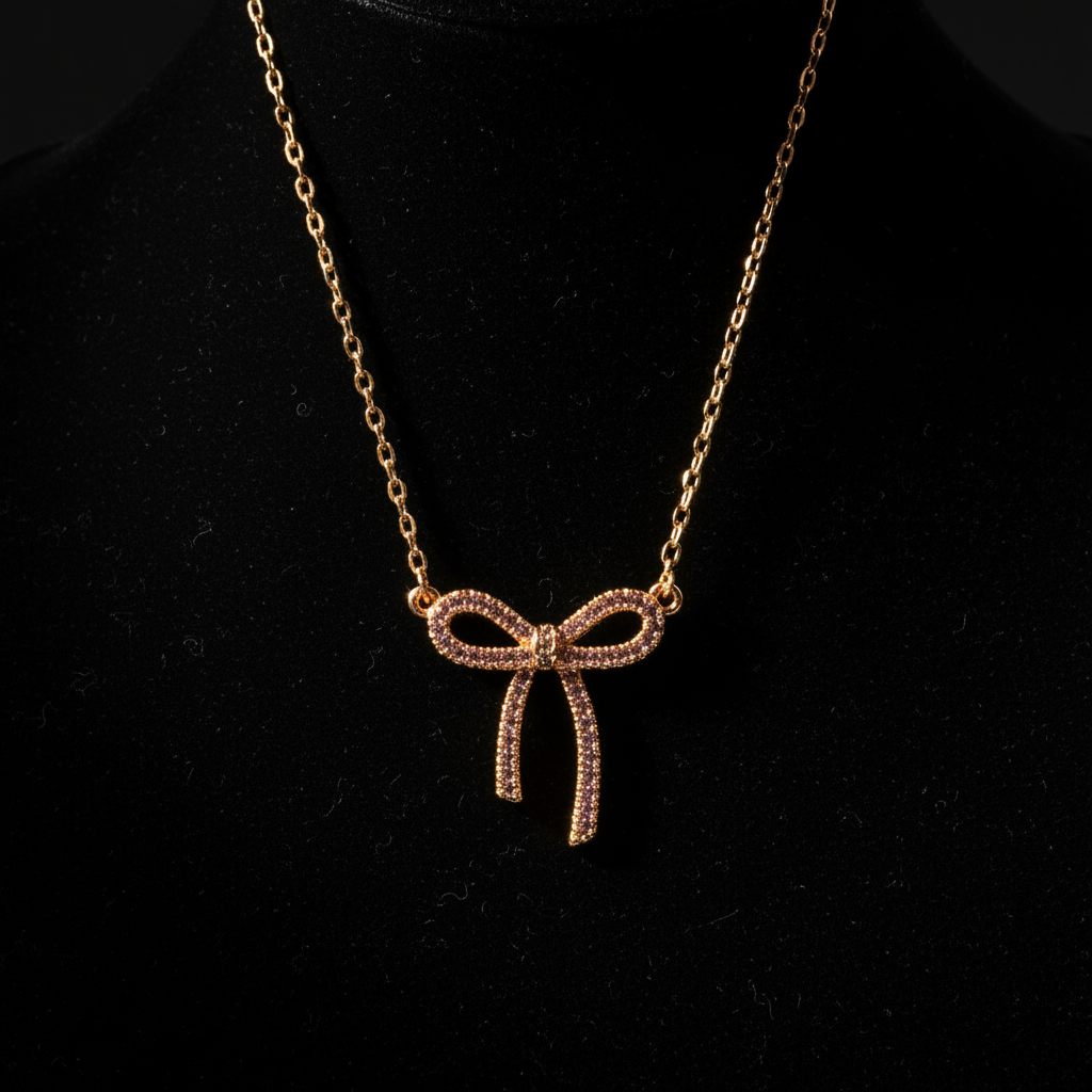Gold bow-shaped necklace on a black background