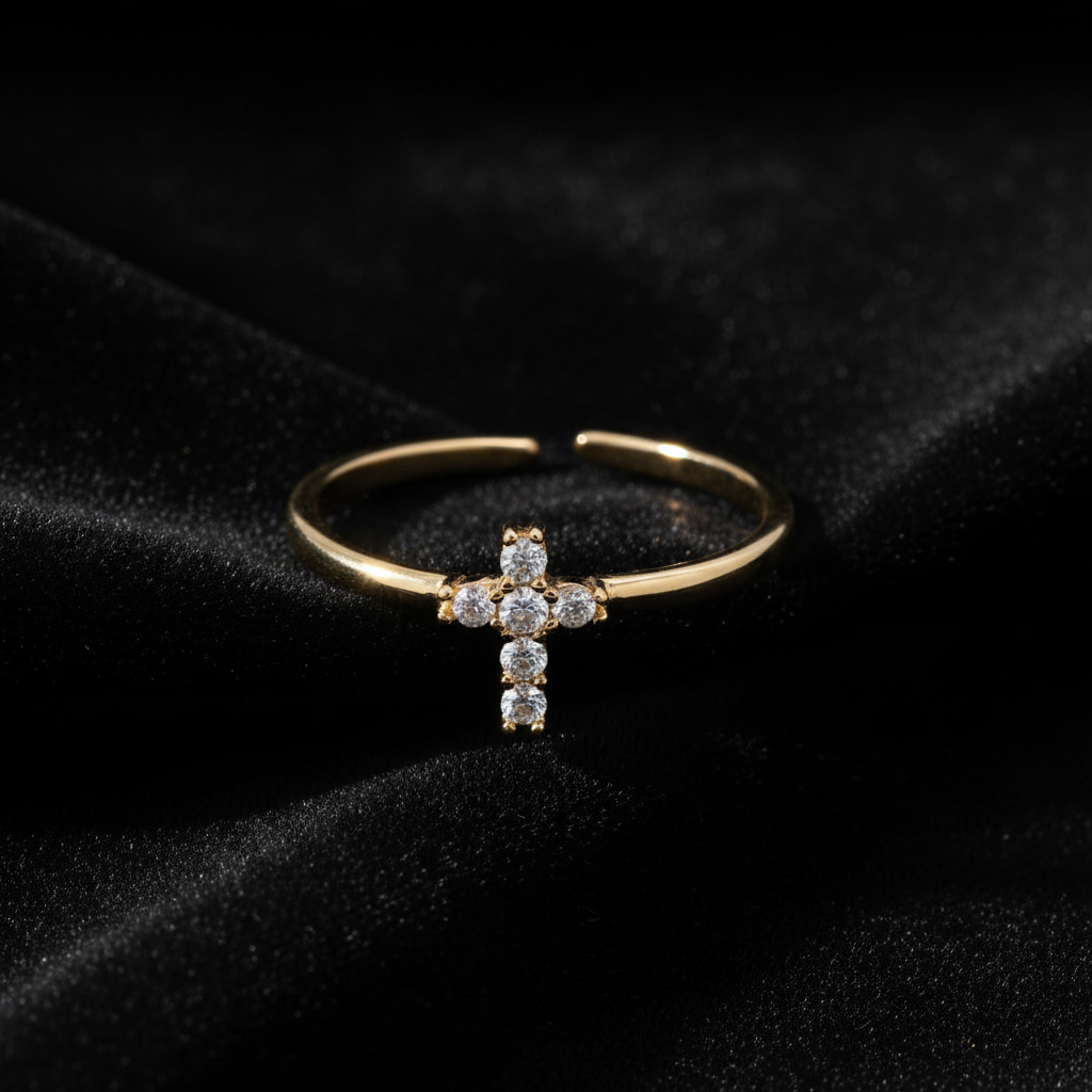 Gold ring with a cross design on a black velvet background