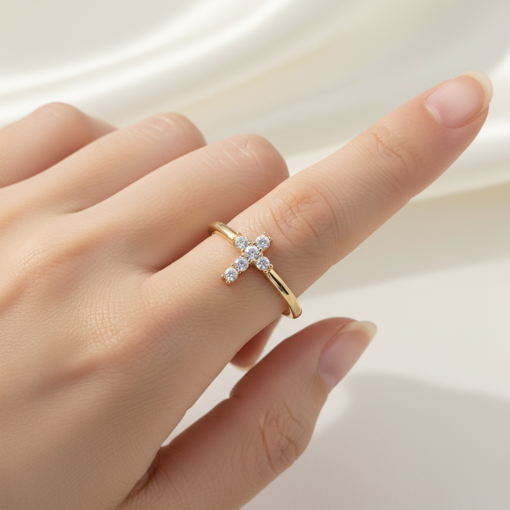 Gold bracelet with a cross charm on a white background