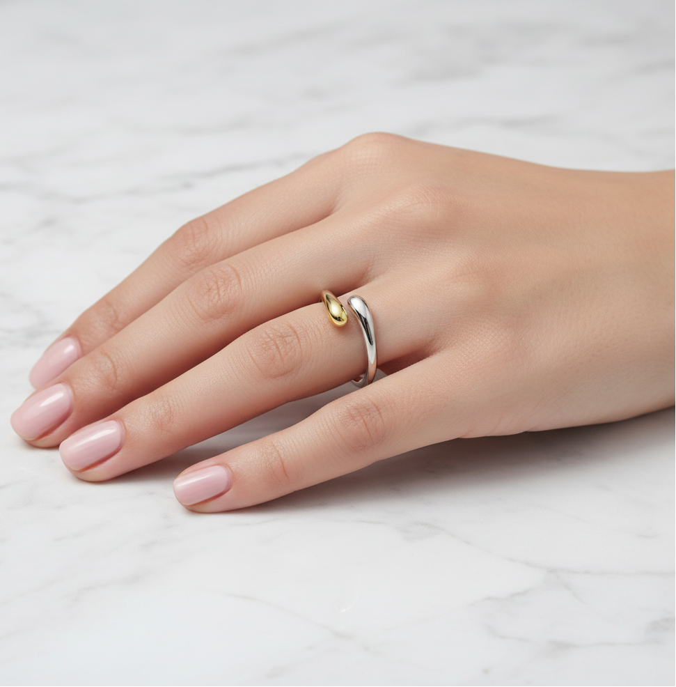 Hand wearing a rings on a light marble background