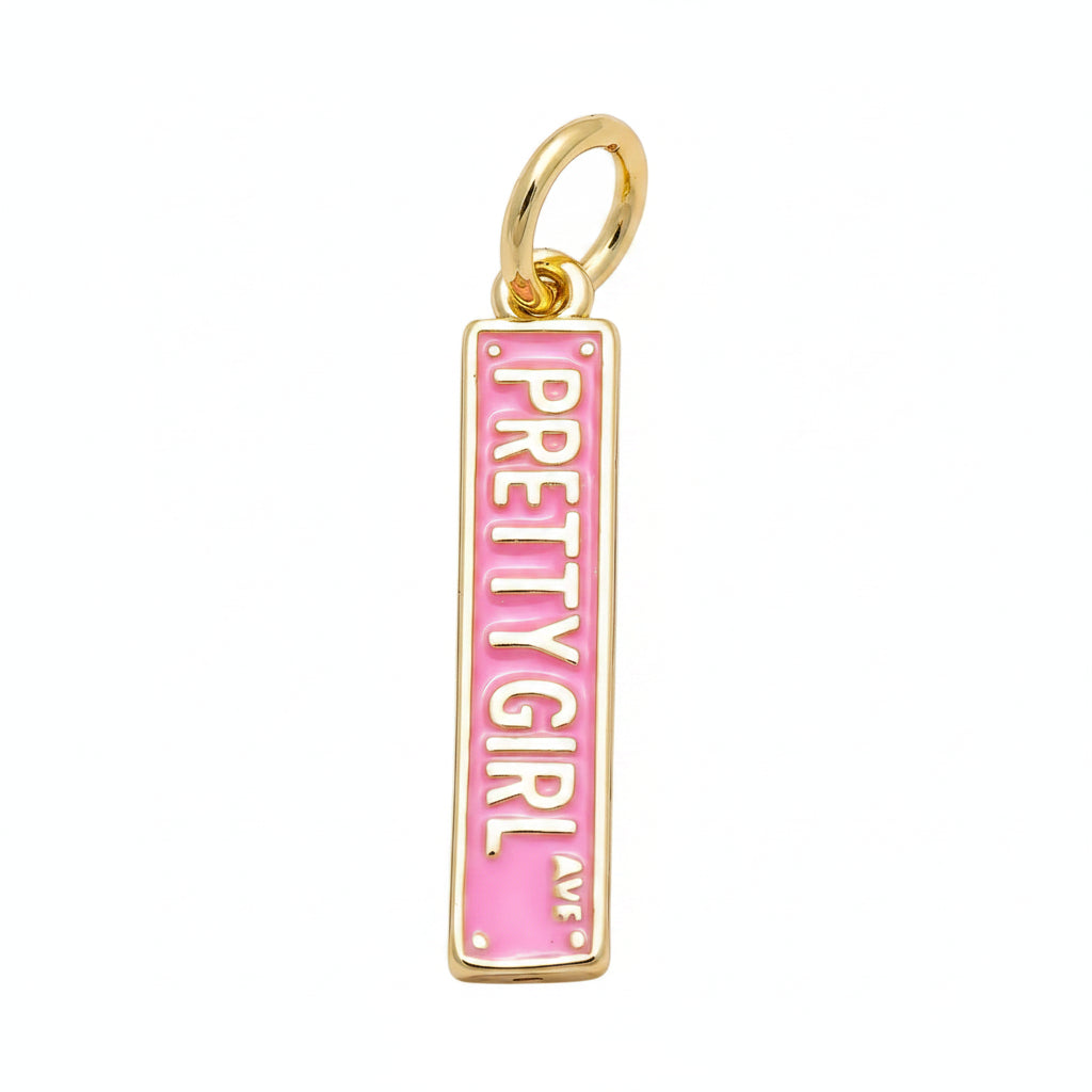 A rectangular gold charm pendant with a pink enamel background and the words 'PRETTY GIRL AV.' printed vertically in gold, shown on a plain white background.