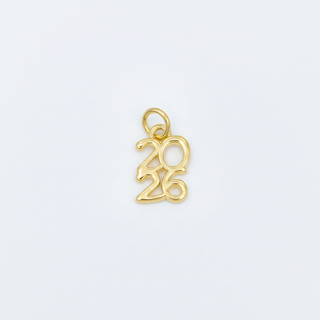 A gold charm shaped like the year '2026' in a cursive script, displayed on a light blue background.