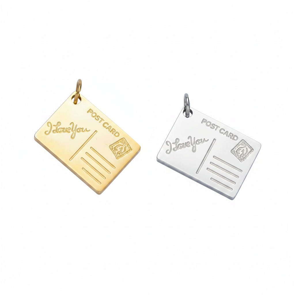 Two postcard-shaped pendant charms on a light blue background, one in gold and one in silver, both engraved with 'POST CARD' and 'I love You'.