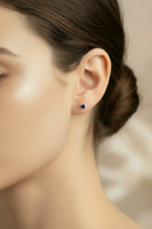 Close-up of a woman wearing a blue earring with a blurred background