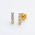 Gold earrings with clear gemstones on a white background