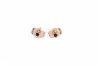 Rose gold earrings with black gemstones on a light blue background