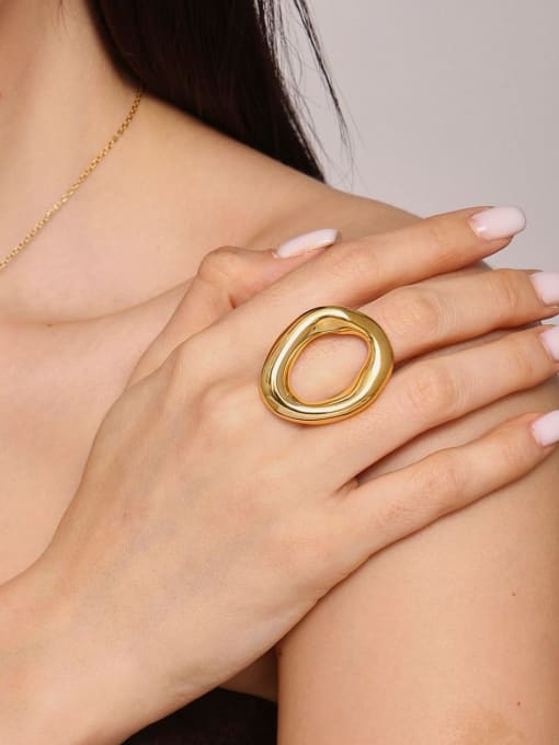 Gold ring on a hand with a neutral background