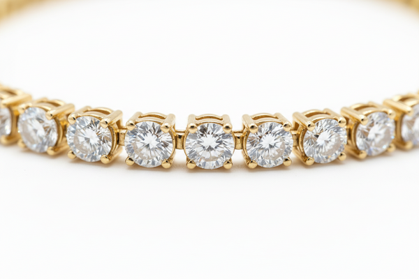 Gold bracelet with clear gemstones on a white background