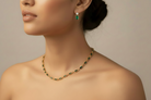 Necklace and earrings on a model against a neutral background