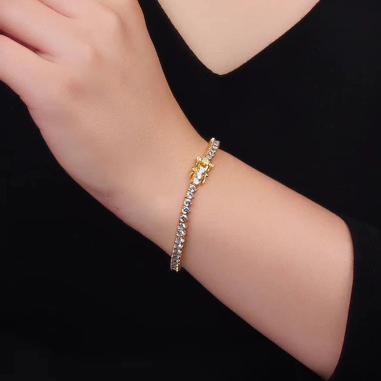 Gold bracelet with clear stones on a wrist against a black background
