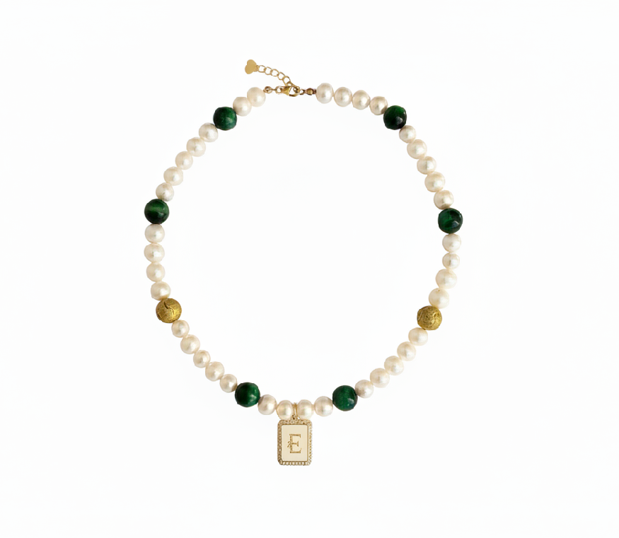 Gold necklace with green stones on a white background