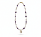 Pearl necklace with purple beads on a white background