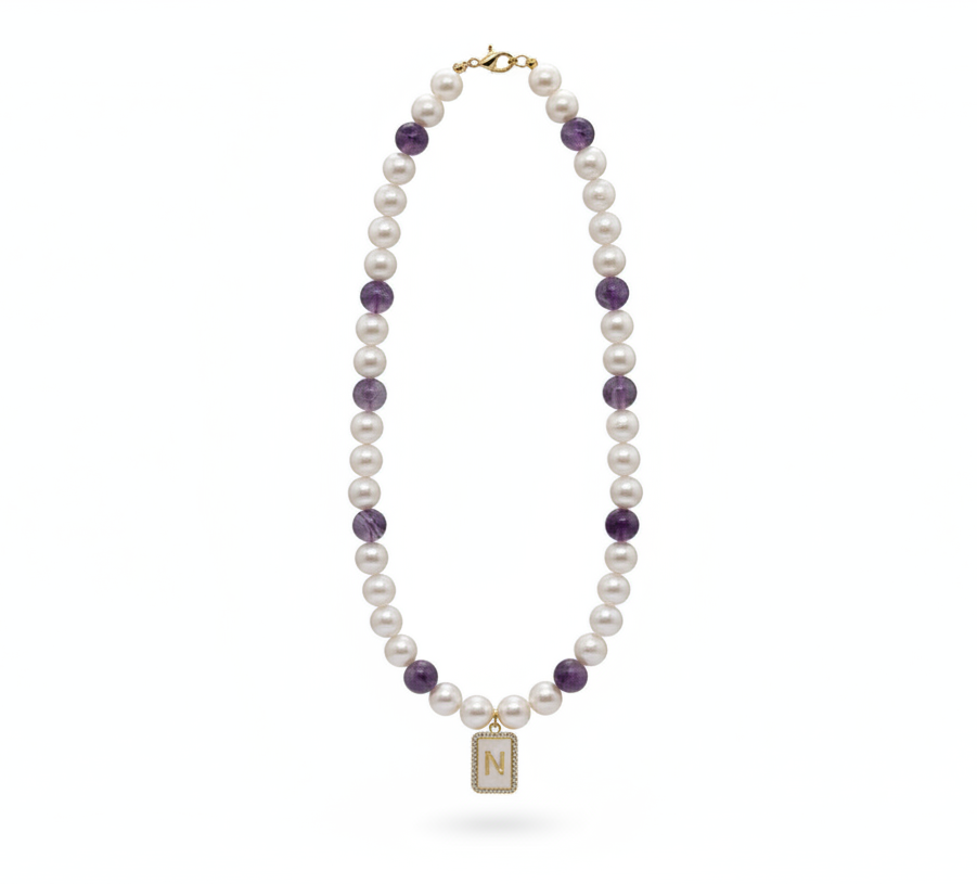 Pearl necklace with purple beads on a white background