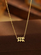 Gold necklace with a unique pendant on a brown surface