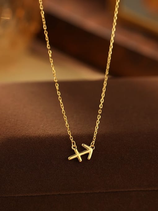 Gold necklace with a small airplane pendant on a brown surface