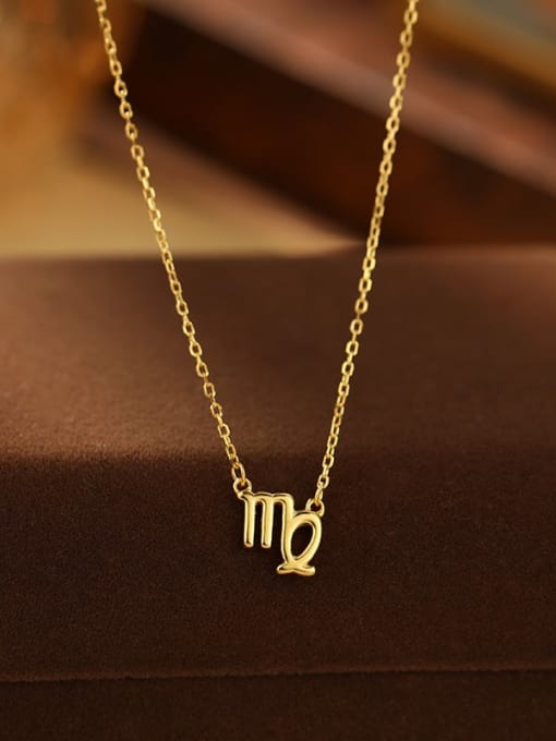Gold necklace with a zodiac sign pendant on a brown surface