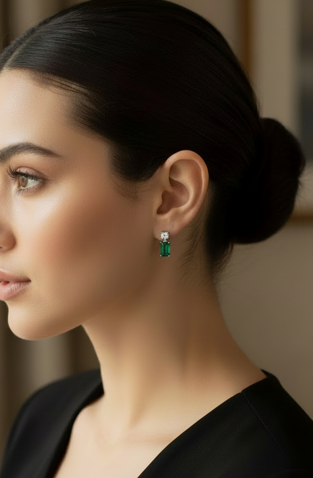 Woman with a bun hairstyle wearing green earrings indoors