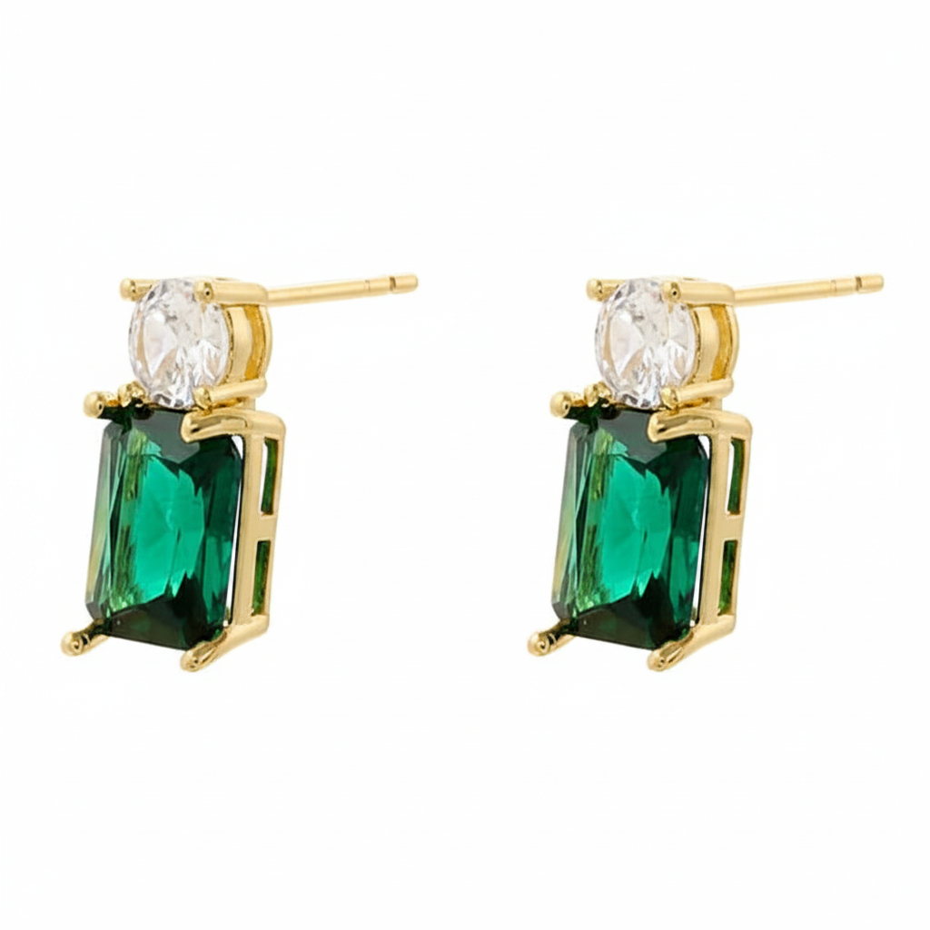 Gold earrings with emerald green gemstones on a white background