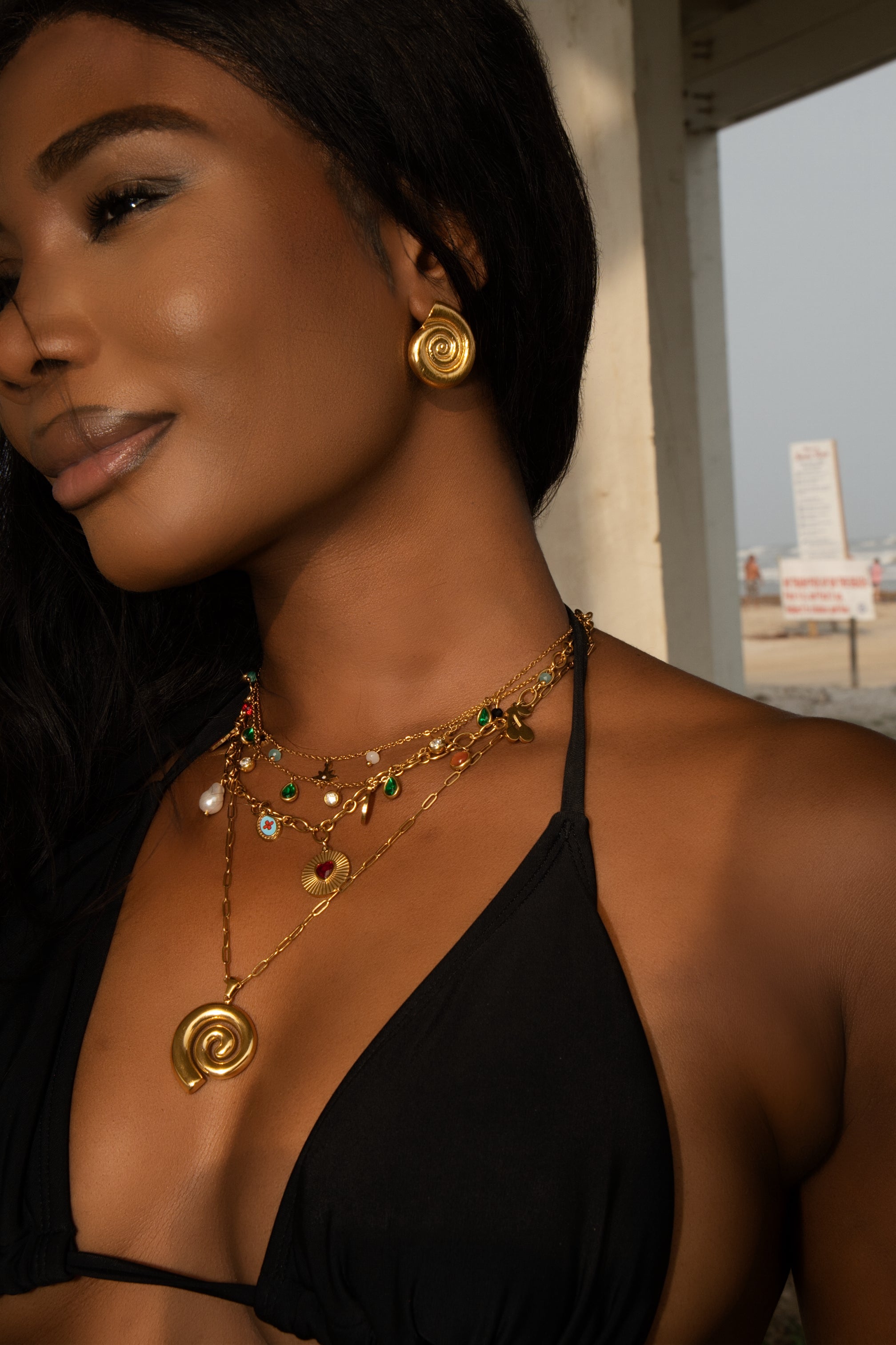 Woman wearing gold jewelry with a blurred background