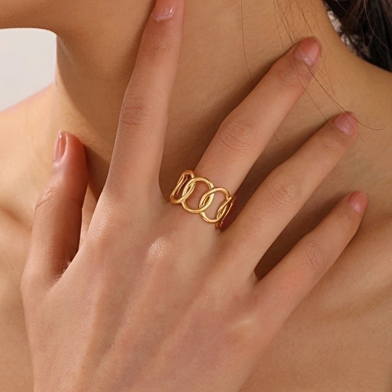 Gold ring on a finger with a neutral background