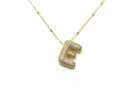 Gold necklace with a 'E' pendant on a white background 