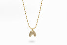 Gold chain necklace with a bubble letter pendant against a white background.