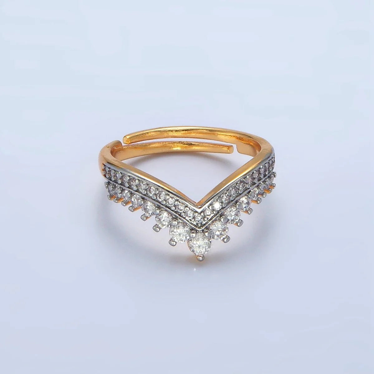 Gold and silver ring with diamond accents on a light gray background